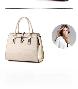 Detail of off-white handbag with crocodile embossed texture and light gold metal accents