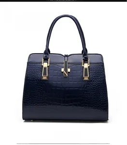 Front view of deep blue crocodile textured handbag with polished gold hardware detail