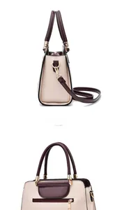 Detail of cream and burgundy faux leather handbag with golden hardware and rear zip pocket