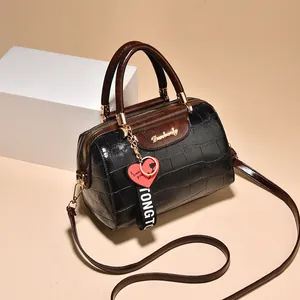 Bolso Boston retro de piel de cocodrilo negra con asas marrones y detalles dorados