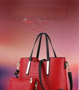 Detail of red crocodile texture tote and clutch set with black handles and metal hardware
