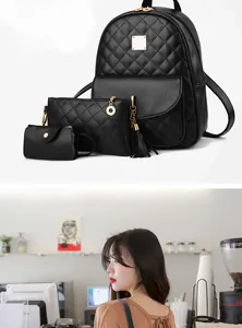 Detail of black quilted backpack set with golden hardware and leather tassel accent