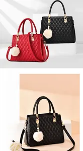 Close-up of diamond quilted handbag texture with plush ball and pearl pendant detail