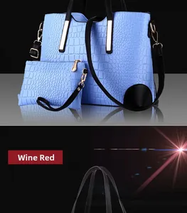 Detail of light blue crocodile-embossed tote bag set with elegant gold hardware buckles