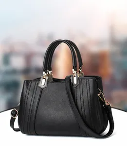 Detailaufnahme der schwarzen Handtasche mit Stickerei, Goldbuckles und Lederstruktur