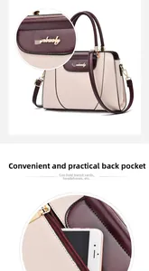 Detail view of the back zipper pocket on a cream and burgundy contrast handbag
