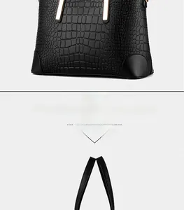 Detail of black crocodile embossed leather handbag with premium gold hardware accents