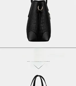 Detailed side view of black crocodile pattern handbag with elegant gold hardware