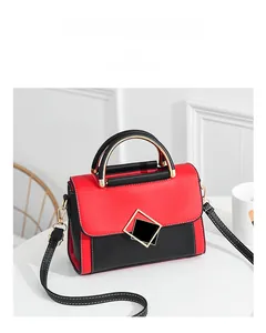 Detail view of red and black color-block PU square bag with square metal buckle on table