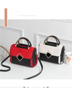 Detail showing two-tone PU leather crossbody bags with metal diamond buckles and top handles