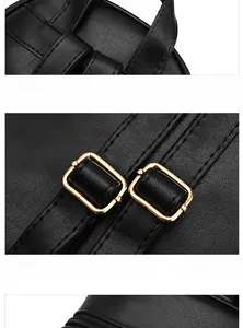 Close-up of black quilted leather backpack showing soft handle and gold metal buckles