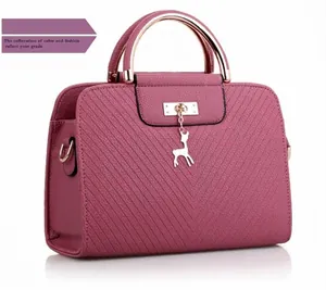 Detail of mauve pink handbag with textured leather and deer pendant attachment