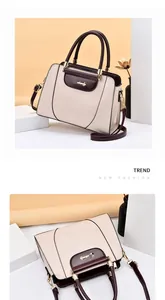 Detail view of the contrast beige and brown tote bag with gold hardware and brand logo