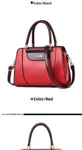 Close-up detail of red faux leather handbag with brown handles and gold logo