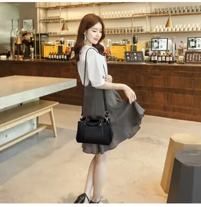 Detailansicht einer schwarzen Lederhandtasche mit Ziernähten in einem Café
