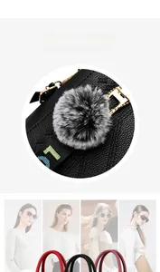 Nahaufnahme eines flauschigen Kunstfell-Anhängers an einer schwarzen Lederhandtasche