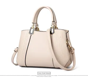 Detailansicht der gestreiften Khaki-Handtasche mit Goldbeschlägen und Ziernähten