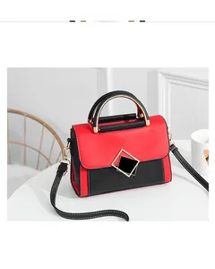 Detail view of red and black contrast PU crossbody bag with gold round handle and stitching