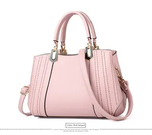 Nahaufnahme der rosa Handtasche mit vertikalen Nähten und goldenen Metallteilen