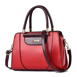 Fashionable red and brown tote bag with gold logo and adjustable shoulder strap
