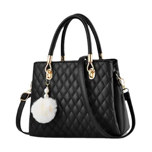 Classic black quilted handbag with golden hardware and white pompom charm accessory