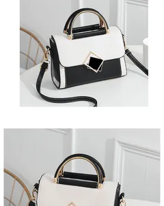 Detail view of stylish black and white PU leather handbag with golden geometric clasp