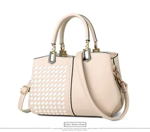Detail der Webstruktur und des glatten khakifarbenen Leders an einer Handtasche