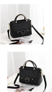 Detail of black lychee leather handbag with gold semicircular handle and metal lock
