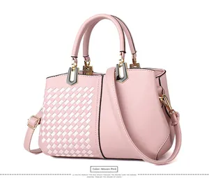 Detail der Webstruktur und glattem rosa Leder der Schultertasche mit Goldbeschlag