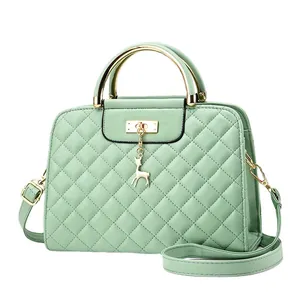 Mint green quilted handbag with deer pendant and gold handles shown at a 45-degree angle