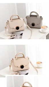 Close-up of minimalist leather handbags with gold metal handles and round buckle