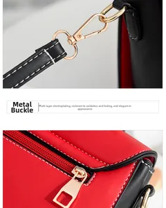 Detail of golden metal clasp and zipper on red and black leather crossbody bag