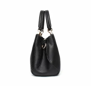 Seitenansicht der schwarzen Handtasche aus Kunstleder mit Details aus goldenem Metall