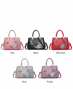 Detalle del juego de bolsos bordados en cinco colores con motivos de flores y abeja