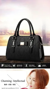 Detail of black PU leather handbag with geometric triangle embossing and bow ornament