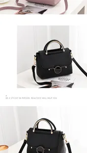 Close-up of litchi grain texture and golden metal handle on black crossbody bag