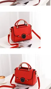 Detail of red pebbled leather small handbag with golden metal handle and round lock
