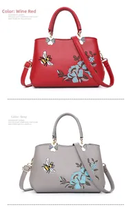 Detail einer eleganten Handtasche mit Blumenbestickung und Kleeblatt-Beschlägen