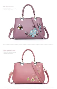 Details der Blumen- und Bienenstickerei und Kleeblatt-Metallbeschläge an Lederhandtaschen