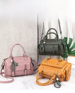 Three vintage PU leather Boston bags in pink, green and yellow with decorative charms