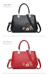 Details von schwarzen und burgunderroten Handtaschen mit Blumen- und Schmetterlingsstickerei