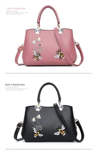 Detail der Bienen- und Gänseblümchen-Stickerei auf schwarzen und rosa PU-Handtaschen