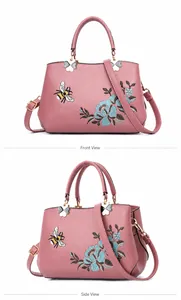 Detalle del bordado floral con abeja y herrajes de mariposa en un bolso rosa elegante