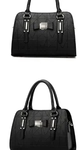 Detail of black handbag showing geometric texture and elegant bow with metal hardware