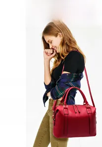 Détail d'un grand sac à main rouge en similicuir brillant avec des sangles verticales chic
