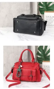 Detailed view of pebbled leather Boston bag with metal feet and star pearl charm accessory