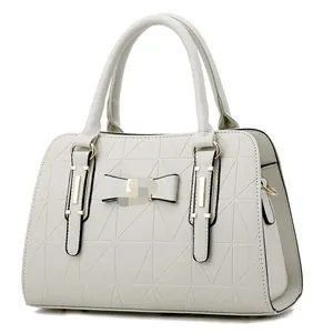 Elegant ivory quilted handbag with a bow accent and gold hardware on white background