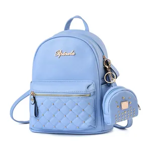 Close-up of light blue pebbled leather backpack with gold rivets and round coin purse