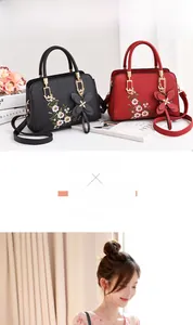 Detailed view of floral embroidery and butterfly charm on structured PU leather handbags