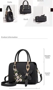 Detail view of black PU handbag with floral embroidery and golden hardware accents